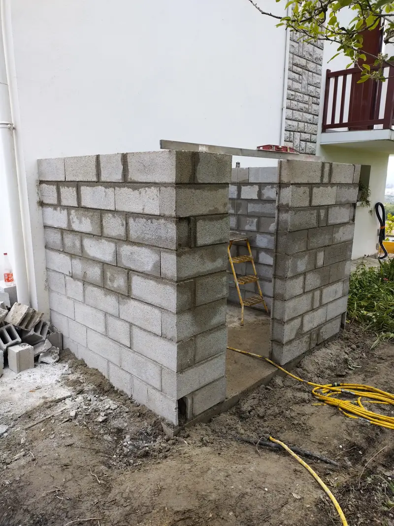 Annexe maçonnée. Élévation en blocs sur dalle, réservation de porte.