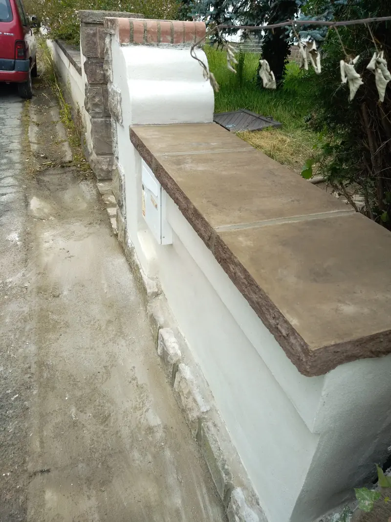 Mur de clôture. Enduit, couvertine et niche pour coffrets.